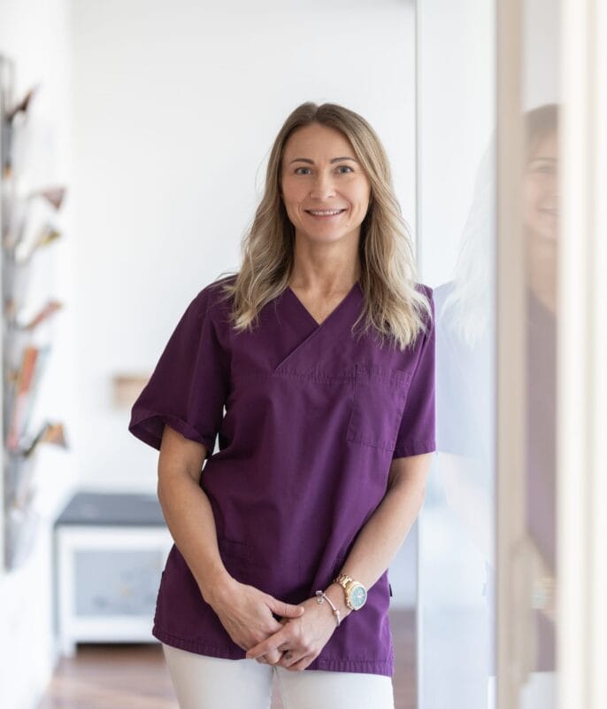 Marina Seel, Mitarbeiterin des Praxisteams der gastroenterologischen Praxis Dr. med. Stockhammer, im hellen Praxisflur stehend.